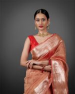 "Model draped in a stunning orange crushed tissue silk saree, radiating elegance and warmth." By Mirra Clothing