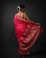 Back view of a model showcasing Rani Pink Banarasi Georgette Saree With Gold Zari weaves , Ideal for vintage or ethnic-themed celebrations by Mirra Clothing