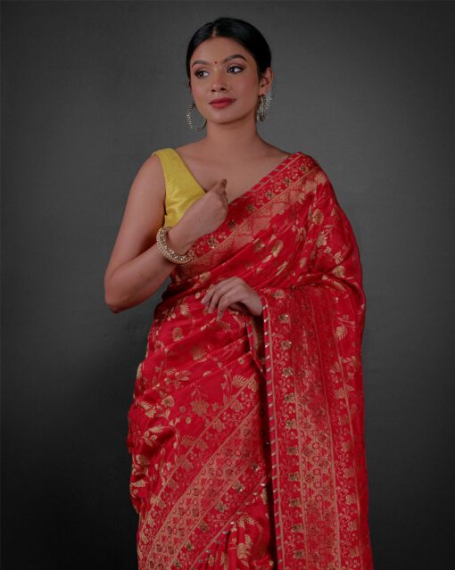 Front view of a model showcasing a Peachy Red Banarasi Silk Saree Highlighted with Embroidery, Suitable for traditional performances or fairs By Mirra Clothing