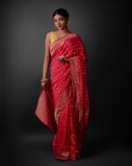 Front view of a model showcasing a Rani Pink Banarasi Georgette Saree With Gold Zari weaves , Elegant attire for religious rituals and ceremonies By Mirra Clothing