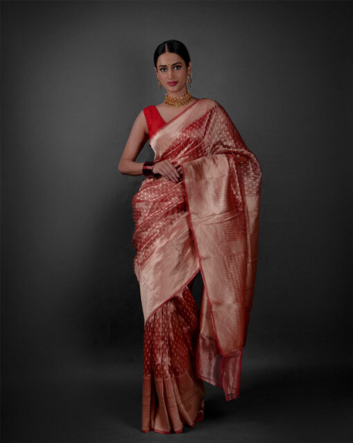 "Elegant red tissue saree draped gracefully on a Model paired up with Maroon Bangles by Mirra Clothing