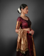 Side view of a model showcasing Coffee Brown Silk Half Saree Set with Tissue Silk Dupatta, Designed for festive wedding occasions By Mirra Clothing