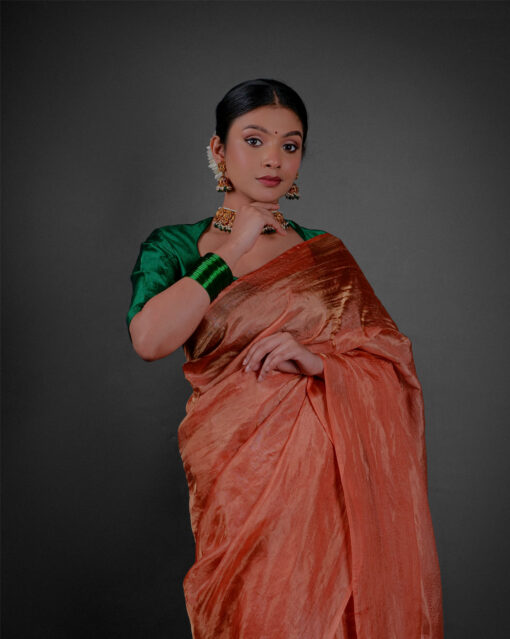 Close up view of a model showcasing Orange Tissue Silk Saree , Suitable for festive times By Mirra Clothing