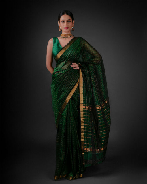 "A beautifully draped traditional Green saree with intricate gold Zari showcasing a classic Indian attire." by Mirra Clothing