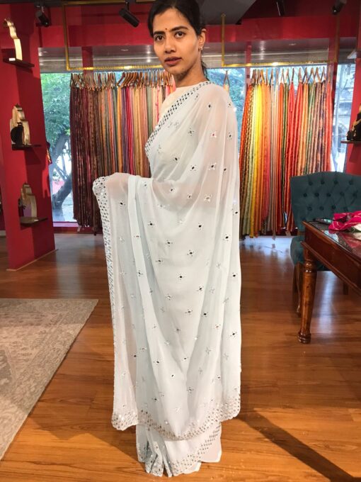 Side view of a model showcasing Baby Blue Chiffon Silk Saree Embellished with Mirrors, Designed for Glamorous NightsSide view of a model showcasing Baby Blue Chiffon Silk Saree Embellished with Mirrors, Designed for Glamorous Nights BY Mirra Clothing